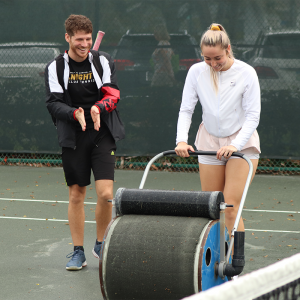 Gaccione and teammate help dry the courts at the 2020 Tennis on Campus Delray Beach Challenge