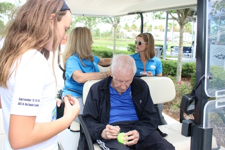 Bobby autographs tennis balls for players at the 2019 USTA Florida Bobby Curtis Junior 16s/18s Sectionals Doubles Championships