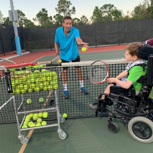 Wheelchair player practicing with a certified tennis professional