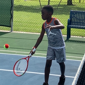 Boy hitting ball on the court
