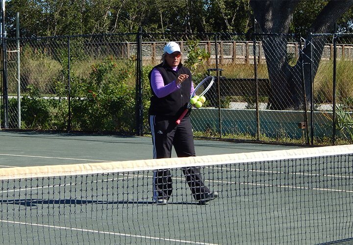 Kim Scullion stands behind the net teaching